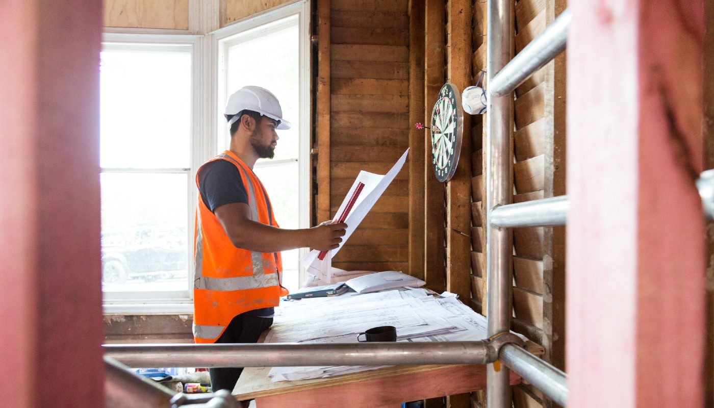 Construction worker looks at building layout. There were two recent High Court Cases that provided rulings on whether some workers are employees or contractors.